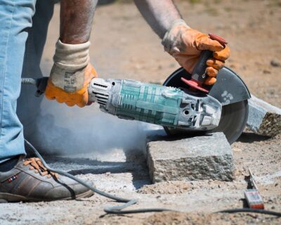 man cuts paver with grinder